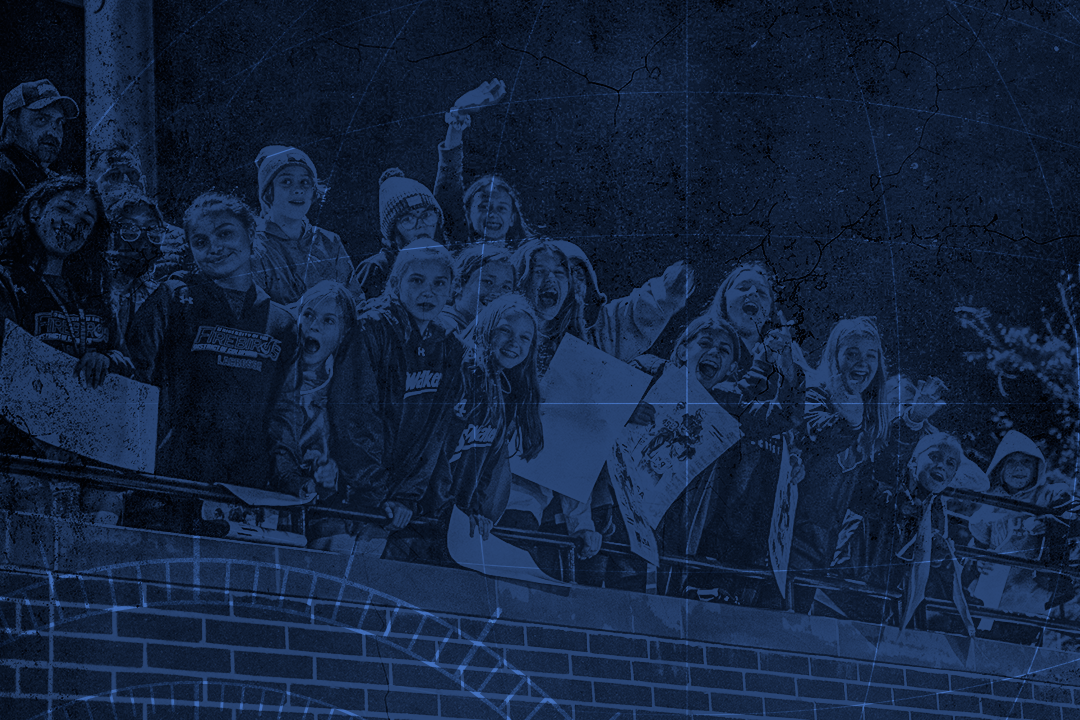 Fans in the stands with signs at USA Lacrosse's Tierney Field